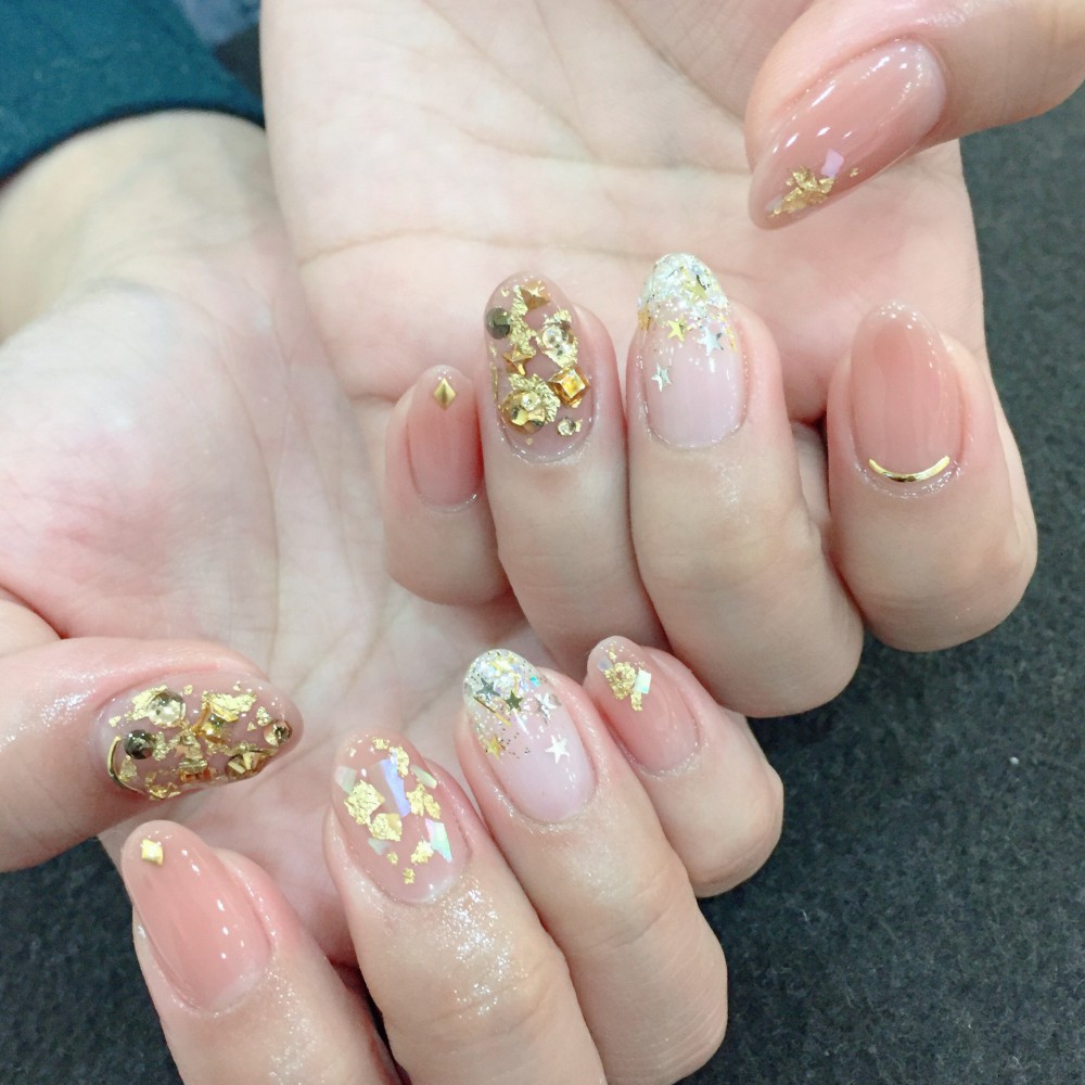 以粉橙色和裸色作指甲底色,再加上金箔和其他小巧金属配饰,高贵中透著